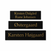 Sort postkasseskilt med guldfarvet tekst